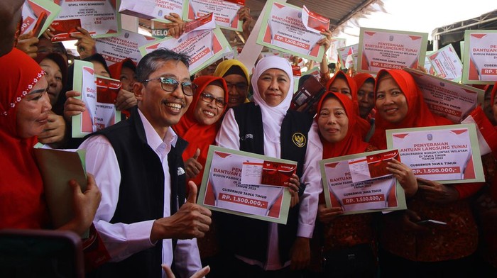 Penyerahan BLT buruh pabrik rokok Gubernur Jawa Timur Khofifah Indar Parawansa (tengah) membawa Bendera Merah Putih didampingi Direktur PT HM Sampoerna Tbk Elvira Lianita (kanan) di sela penyerahan Bantuan Langsung Tunai (BLT) di Surabaya, Jawa Timur, Kamis (24/8/2023). Sebanyak 9.259 pekerja pabrik rokok di Jawa Timur mendapat BLT Provinsi masing-masing sebesar Rp1,5 juta yang berasal dari Dana Bagi Hasil Cukai dan Hasil Tembakau (DBHCHT). ANTARA FOTO/Moch Asim/nym.