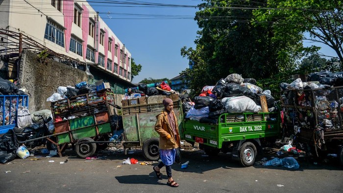 Ribuan Ton Sampah Kota Bandung Numpuk Imbas Kebakaran TPA Sarimukti Warga melintas di samping sampah yang menumpuk di TPS Pasar Ancol, Bandung, Jawa Barat, Kamis (24/8/2023). Dinas Lingkungan Hidup Kota Bandung menyatakan, ribuan ton sampah dari Kota Bandung tidak bisa dikirim ke TPA Sarimukti untuk sementara imbas dari terjadinya kebakaran TPA yang hingga saat ini masih terjadi. ANTARA FOTO/Raisan Al Farisi/foc.