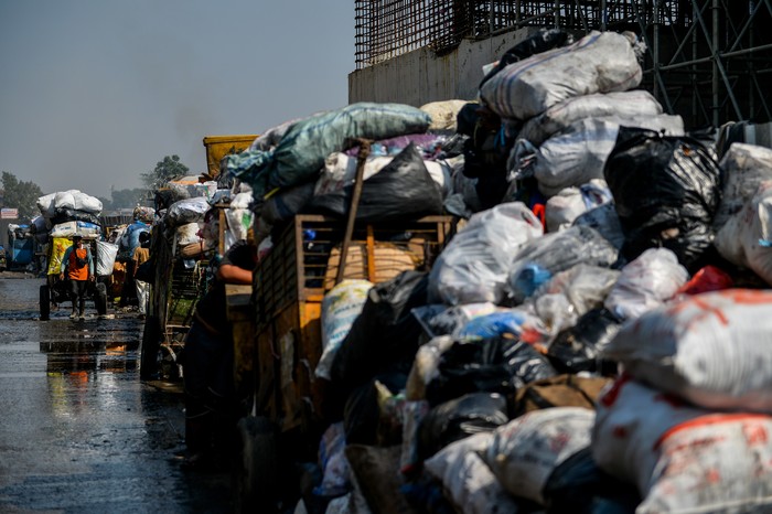 Warga melintas di samping sampah yang menumpuk di TPS Pasar Ancol, Bandung, Jawa Barat, Kamis (24/8/2023). Dinas Lingkungan Hidup Kota Bandung menyatakan, ribuan ton sampah dari Kota Bandung tidak bisa dikirim ke TPA Sarimukti untuk sementara imbas dari terjadinya kebakaran TPA yang hingga saat ini masih terjadi. ANTARA FOTO/Raisan Al Farisi/foc.