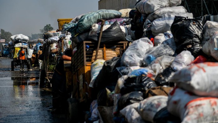 Warga melintas di samping sampah yang menumpuk di TPS Pasar Ancol, Bandung, Jawa Barat, Kamis (24/8/2023). Dinas Lingkungan Hidup Kota Bandung menyatakan, ribuan ton sampah dari Kota Bandung tidak bisa dikirim ke TPA Sarimukti untuk sementara imbas dari terjadinya kebakaran TPA yang hingga saat ini masih terjadi. ANTARA FOTO/Raisan Al Farisi/foc.