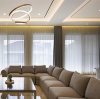 Ruang keluarga yang luas dilengkapi sofa panjang yang dapat mengakomodasi banyak orang. Fitur mood lighting di langit-langit semakin menciptakan atmosfer yang hangat saat berkumpul. (Foto: YouTube/DMC Architect & Interior Studio)