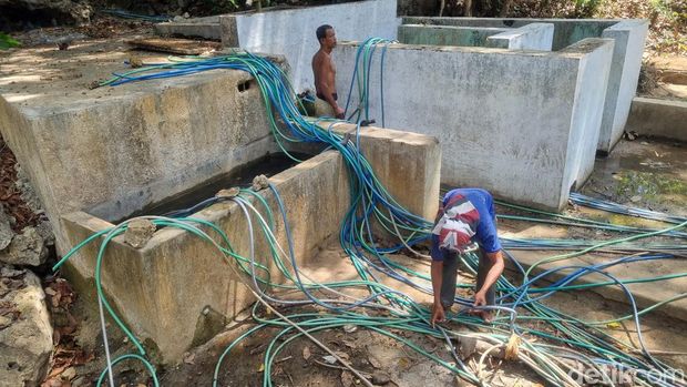 Suasana penyedotan air melalui selang di sumber mata air Padukan, RT.02, Pedukuhan Kalidadap I, Kalurahan Selopamioro, Kapanewon Imogiri, Kabupaten Bantul, Kamis (24/8/2023).