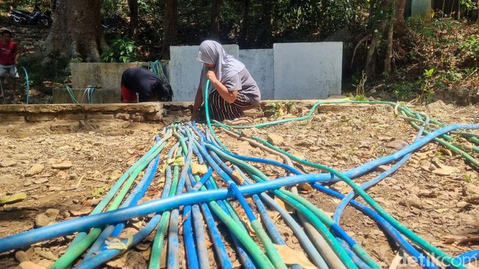 Suasana penyedotan air melalui selang di sumber mata air Padukan, RT.02, Pedukuhan Kalidadap I, Kalurahan Selopamioro, Kapanewon Imogiri, Kabupaten Bantul, Kamis (24/8/2023).