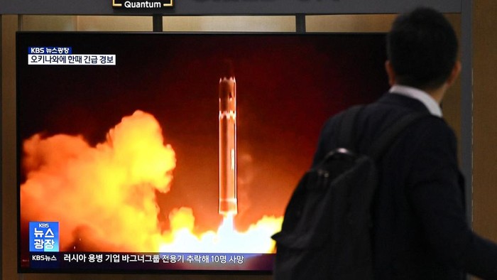 A man walks past a television screen showing a news broadcast with file footage of a North Korean missile test, at a railway station in Seoul on August 24, 2023. North Koreas latest attempt to put a spy satellite into orbit has ended in failure, state media said on August 24, just months after Pyongyangs first launch crashed into the ocean shortly after blast off. (Photo by Jung Yeon-je / AFP)