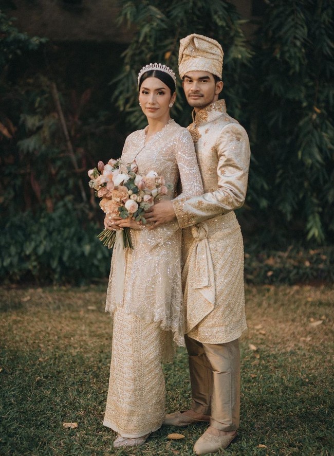 Mengenakan pakaian adat Aceh Tamiang, Tyas Mirasih tampil anggun dalam balutan kebaya pengantin dengan aksen payet dan bordir. Istri Tengku Tezi ini menyempurnakan penampilan dengan tiara minimalis sebagai hiasan di kepala, dan rok bernuansa gold yang mewah. Foto: Instagram/@tyasmirasih @morden.co