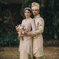 Mengenakan pakaian adat Aceh Tamiang, Tyas Mirasih tampil anggun dalam balutan kebaya pengantin dengan aksen payet dan bordir. Istri Tengku Tezi ini menyempurnakan penampilan dengan tiara minimalis sebagai hiasan di kepala, dan rok bernuansa gold yang mewah. Foto: Instagram/@tyasmirasih @morden.co