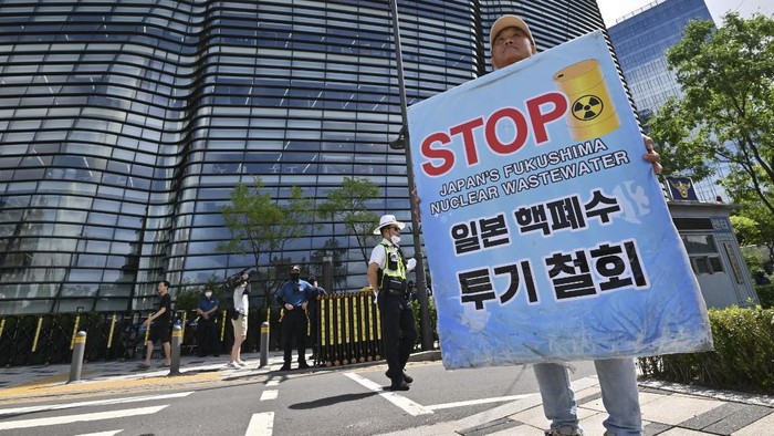 A South Korean man holds a placard in front of a building housing the Japanese embassy in Seoul on August 24, 2023, as South Korean protesters gather to demonstrate against Japans discharge of treated wastewater from the crippled Fukushima nuclear plant. (Photo by Jung Yeon-je / AFP)