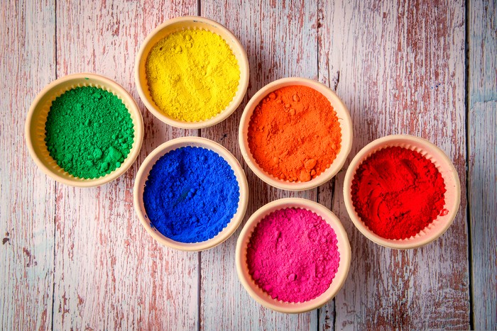 top view of colorful traditional holi powder in bowls isolated on dark background.Space for text . happy holi.Concept Indian color festival called Holi