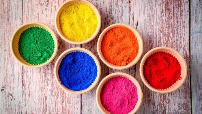 top view of colorful traditional holi powder in bowls isolated on dark background.Space for text . happy holi.Concept Indian color festival called Holi