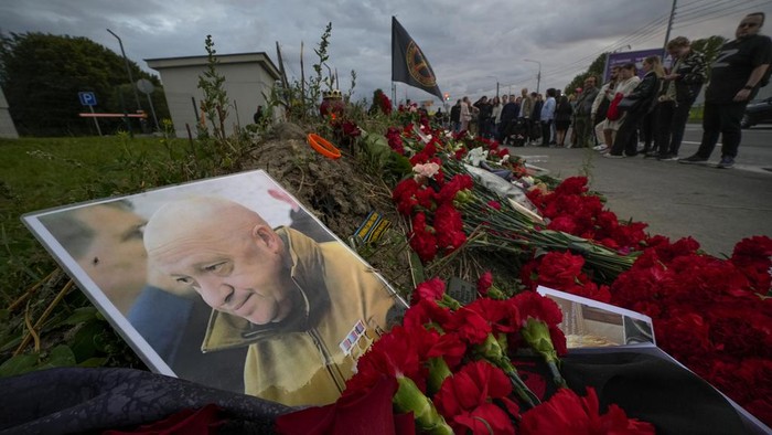 A man lights candles at a informal memorial next to the former PMC Wagner Centre in St. Petersburg, Russia, Thursday, Aug. 24, 2023. Russias civil aviation agency says mercenary leader Yevgeny Prigozhin was aboard a plane that crashed north of Moscow. (AP Photo/Dmitri Lovetsky)