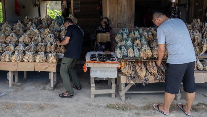Wisatawan memilih-milih ikan asin kering untuk cinderamata di Pagimana, Banggai, Sulawesi Tengah, Jumat (25/8/2023). Selain dipasarkan ke berbagai wilayah di Sulawesi, ikan asin kering yang kualitasnya dikenal terbaik di daerah itu juga dijual sebagai cinderamata bagi para wisatawan  domestik dengan harga antara Rp50 ribu hingga Rp120 ribu per kilogram tergantung jenis ikan dan beratnya. ANTARA FOTO/Basri Marzuki/foc.