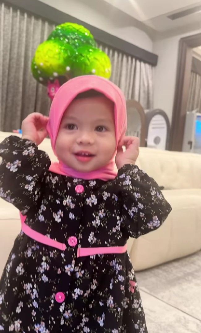 Pose Ameena membuat orang sekitarnya tertawa. Ameena pun berpose sambil memegang hijabnya. Foto: Dok. Instagram @aurelie.hermansyah.