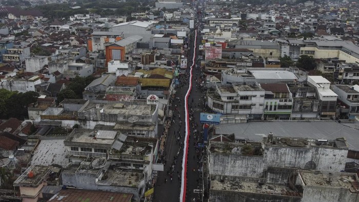 Kirab kebangsaan Merah Putih di Tasikmalaya Foto udara peserta membentangkan bendera merah putih saat kirab kebangsaan di Kota Tasikmalaya, Jawa Barat, Jumat (25/8/2023). Kirab merah putih yang diikuti dari masyarakat, tokoh lintas agama, TNI dan Polri se-Priangan Timur itu, bertujuan untuk menjaga persatuan NKRI dan menumbuhkan nasionalisme dan sikap toleransi antarberagama. ANTARA FOTO/Adeng Bustomi/aww.
