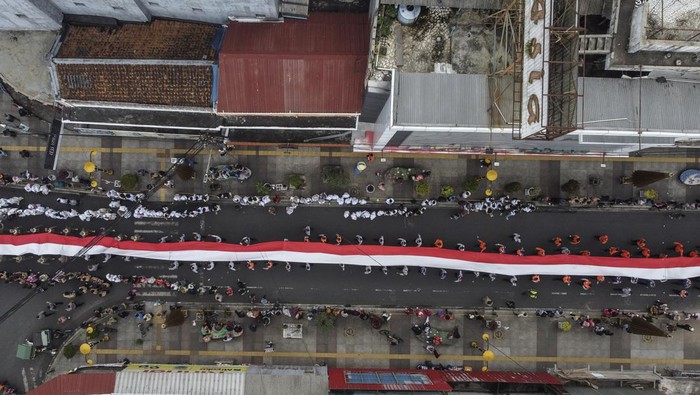 Kirab kebangsaan Merah Putih di Tasikmalaya Foto udara peserta membentangkan bendera merah putih saat kirab kebangsaan di Kota Tasikmalaya, Jawa Barat, Jumat (25/8/2023). Kirab merah putih yang diikuti dari masyarakat, tokoh lintas agama, TNI dan Polri se-Priangan Timur itu, bertujuan untuk menjaga persatuan NKRI dan menumbuhkan nasionalisme dan sikap toleransi antarberagama. ANTARA FOTO/Adeng Bustomi/aww.