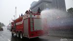 Kurangi Polusi Udara, Pemadam Kebakaran Semprotkan Air ke Jalan
