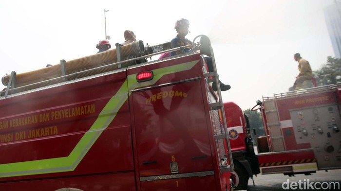 Petugas pemadam kebakaran menyemprotkan air disepanjang jalan MH Thamrin, Jakarta Pusat. Penyemprotan air dilakukan untuk mengurangi polusi di Jakarta.