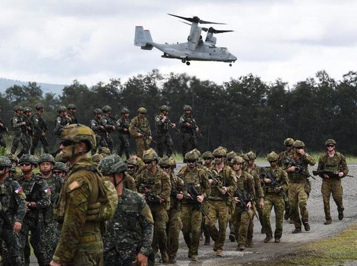 Philippine and Australian soldiers march in formation while a US marines V-22 Osprey hovers above during the military exercise Alon (Wave) at a naval base in San Antonio town in Zambales province. (AFP)