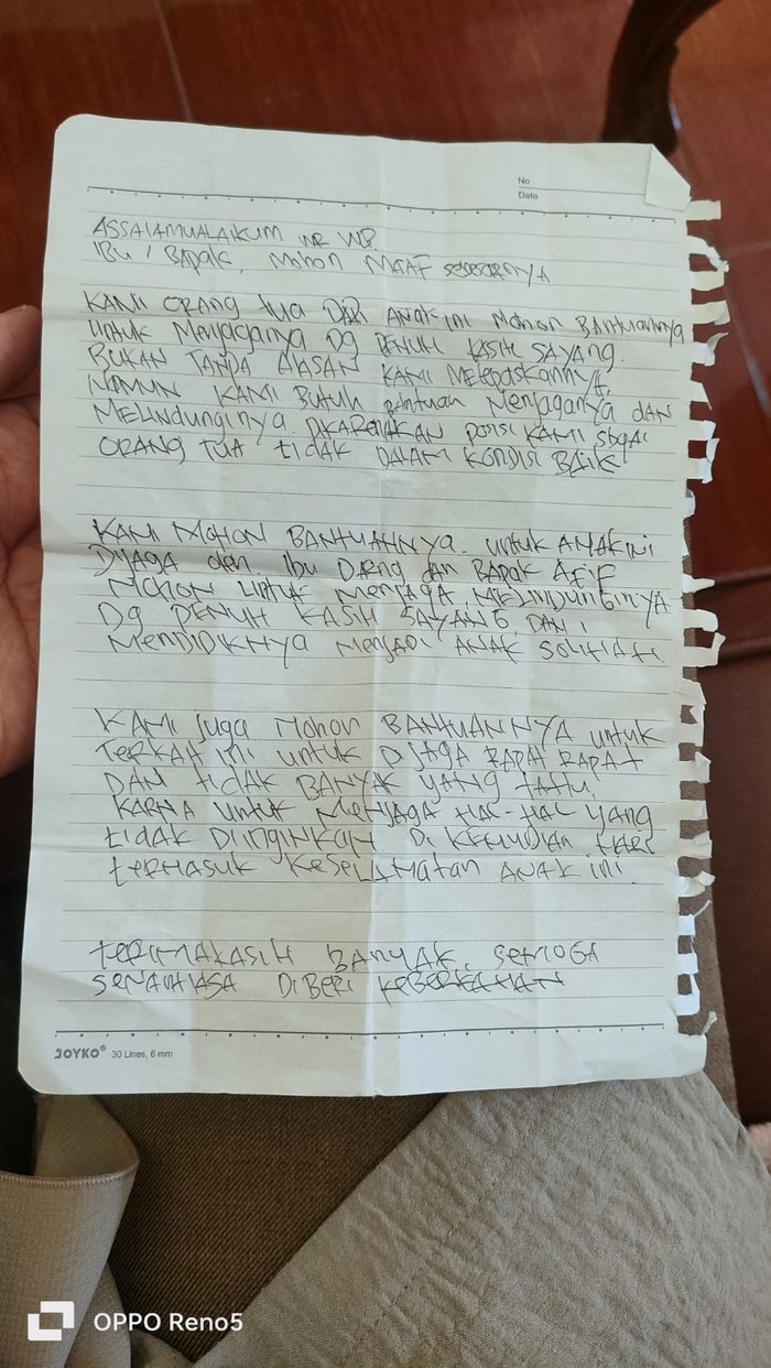 Selembar kertas berisi pesan dari orang tua bayi saat ditemukan.