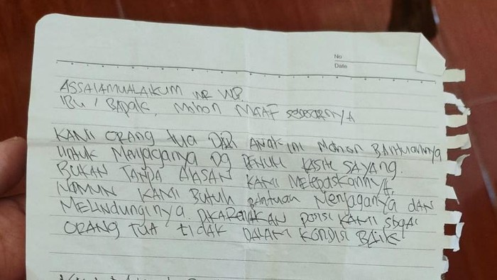 Selembar kertas berisi pesan dari orang tua bayi saat ditemukan.