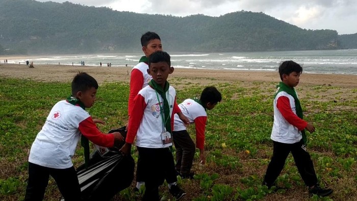 Anggota Palang Merah Remaja bersih-bersih pantai di kawasan Pantai Pancer Door, Pacitan, Sabtu (26/8/2023).