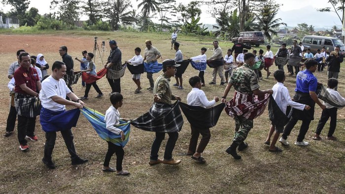 Melestarikan Permainan Tradisional Sasarungan di Tasikmalaya Sejumlah anak mengikuti Kaulinan Barudak menggunakan sarung di Lapang Babancong, Desa Margaluyu, Kabupaten Tasikmalaya, Jawa Barat, Jumat (25/8/2023). Kegiatan yang digelar oleh IJTI Galuh Raya dalam rangka HUT IJTI ke-25 bertemakan Ulin bareng mere tuntunan lain tontonan itu bertujuan untuk membangkitkan kembali permainan tradisional dalam upaya mengurangi penggunaan ponsel yang berlebihan dan membangun budaya gotong-royong sejak dini. ANTARA FOTO/Adeng Bustomi/foc.