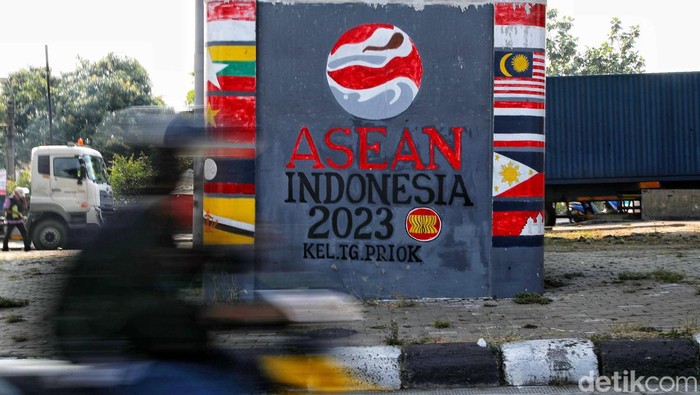 Sejumlah kendaraan melintas di depan mural bertemakan KTT ASEAN  di kawasan Jalan Yos Sudarso, Jakarta Utara, Jumat (25/8/2023). Mural  ini dibuat oleh petugas PPSU untuk menyambut KTT ASEAN pada 5-7 September 2023 mendatang.