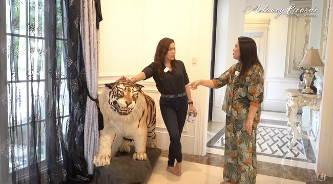 Patung hewan lagi-lagi menghiasi beberapa sudut di dalam rumah. Kali ini harimau yang hampir menyerupai bentuk aslinya. Namun, Dewi memastikan hiasan tersebut bukan hewan taksidermi atau awetan. (Foto: YouTube/MelaneyRicardo)