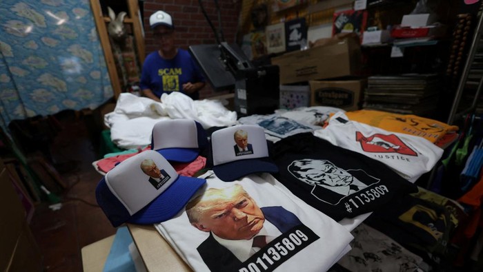 Foto Donald Trump Ditangkap Jadi Merchandise Gelas hingga Baju T-shirts with an image depicting the mugshots of former President Donald Trump and Rudy Giuliani are pictured at the Y-Que printing store in Los Angeles, California, U.S., August 25, 2023. REUTERS/Mario Anzuoni