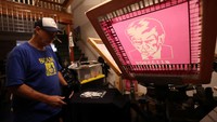 Pemilik toko Bill Wyatt sablon kaos bergambar mantan Presiden AS Donald Trump di toko percetakan Y-Que di Los Angeles, California, AS, Sabtu (26/8/2023).  