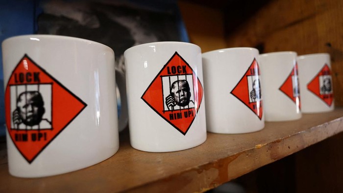 Foto Donald Trump Ditangkap Jadi Merchandise Gelas hingga Baju T-shirts with an image depicting the mugshots of former President Donald Trump and Rudy Giuliani are pictured at the Y-Que printing store in Los Angeles, California, U.S., August 25, 2023. REUTERS/Mario Anzuoni