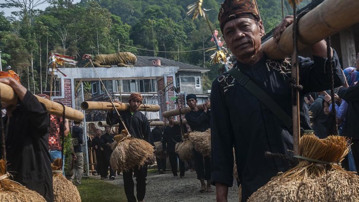 Masyarakat adat Kasepuhan Cisungsang menyimpan padi hasil panen di leuit saat tradisi Seren Taun di Desa Cisungsang, Lebak, Banten, Minggu (27/8/2023). Tradisi Seren taun merupakan upacara adat tahunan sebagai wujud rasa syukur masyarakat Cisungsang atas hasil panen. ANTARA FOTO/Muhammad Bagus Khoirunas/Spt.