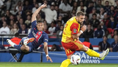 PSGs Kylian Mbappe, left, kicks the ball as Lens Jonathan Gradit challenges it, during the French League One soccer match between Paris Saint-Germain and Lens at the Parc des Princes stadium in Paris, Saturday, Aug. 26, 2023. (AP Photo/Michel Euler)