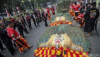 Sejumlah seniman dan warga mengikuti pawai budaya reog Ponorogo di jalan Medan Merdeka Barat, Jakarta, Minggu (27/8/2023). 