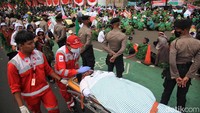 Aksi yang digelar siang hari di tengah panas terik itu membuat salah satu peserta demo pingsan dan ditolong oleh tim medis PMI yang bersiaga selama unjuk rasa.  