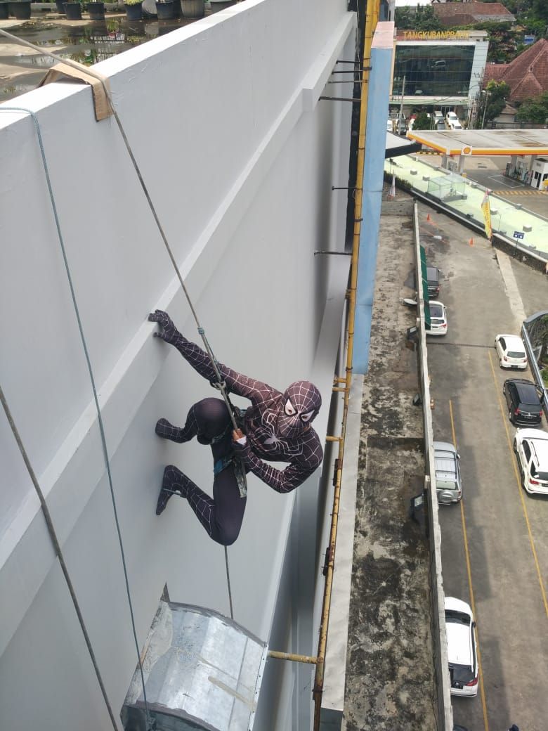 Aksi Spider-Man memanjat untuk membersihkan kaca gedung tinggi di Malang