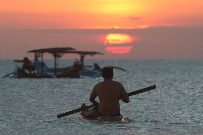 FILE- In this Jan. 18, 2017, file photo, photographers take photos of a tourist couples wedding at the famous Kuta beach during sunset in Bali, Indonesia. According to a 2016 survey from wedding site The Knot, the average cost of an international destination wedding is $25,800. That figure may be within your event budget, but for guests, international airfare and multinight lodging could be out of reach. (AP Photo/Firdia Lisnawati, File)
