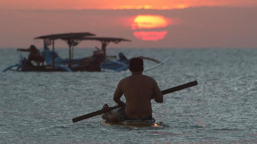 FILE- In this Jan. 18, 2017, file photo, photographers take photos of a tourist couples wedding at the famous Kuta beach during sunset in Bali, Indonesia. According to a 2016 survey from wedding site The Knot, the average cost of an international destination wedding is $25,800. That figure may be within your event budget, but for guests, international airfare and multinight lodging could be out of reach. (AP Photo/Firdia Lisnawati, File)