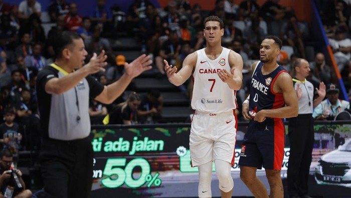 Basketball - FIBA World Cup 2023 - First Round - Group H - Canada v France - Indonesia Arena, Jakarta, Indonesia - August 25, 2023 Canadas Dwight Powell reacts as Frances Elie Okobo looks on REUTERS/Willy Kurniawan