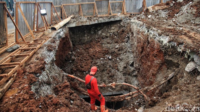 Ini Proyek Gorong-gorong yang Bikin Lebak Bulus Macet Panjang Petugas mengatur arus lalu lintas di sekitar proyek gorong-gorong di perempatan Jalan Ciputat Raya dan Jl RA Kartini, Lebak Bulus, Jakarta Selatan, Senin (28/8/2023). Gorong-gorong sedalam 8,5 meter sedang dikerjakan melintang di bawah badan jalan sehingga menyisakan satu lajur dari arah Ciputat menuju Pondok Pinang. Akibatnya arus kendaraan tersendat dan macet panjang.