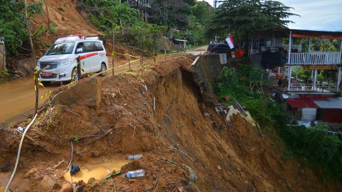 Pengendara motor melewati jalan yang longsor di Jalan Lingkar Nipah - Teluk Bayur, di Bukit Gado-gado Padang, Sumatera Barat, Senin (28/8/2023). Jalan alternatif ke Teluk Bayur sekaligus akses wisata tersebut longsor akibat curah hujan tinggi selama dua hari terakhir dan untuk sementara masih bisa dilewati bergantian namun kondisinya membahayakan pengendara karena banyak material bebatuan di atas bukit.
