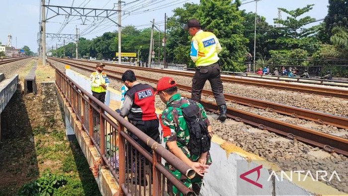 Petugas mengecek pria yang tersambar kereta di Stasiun Buaran, Jakarta Timur.