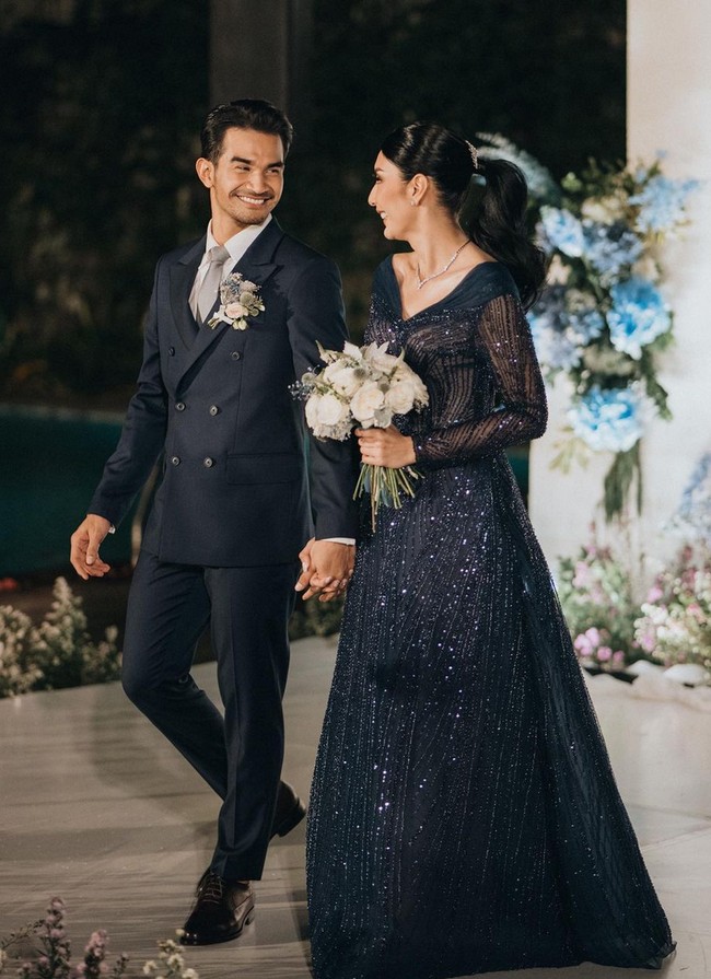 Tyas Mirasih kembali mempercayakan gaun resepsinya kepada Svarna by IKAT Indonesia milik desainer Didiet Maulana yang juga merancang kebaya pengantin saat akad nikah. Kali ini dia memilih warna navy blue. Foto: Instagram/@tyasmirasih @morden.co