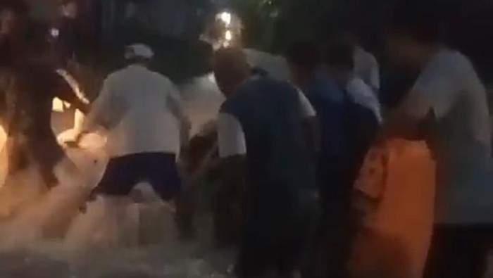 Warga saat berupaya membantu siswi yang terseret banjir di Kota Pematang Siantar. (Foto: Istimewa)