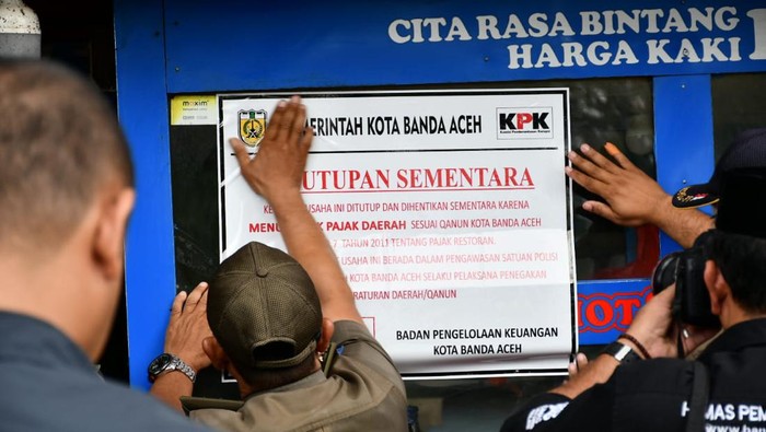 Foto: Petugas menutup sementara tempat usaha nunggak pajak di Banda Aceh. (Istimewa)