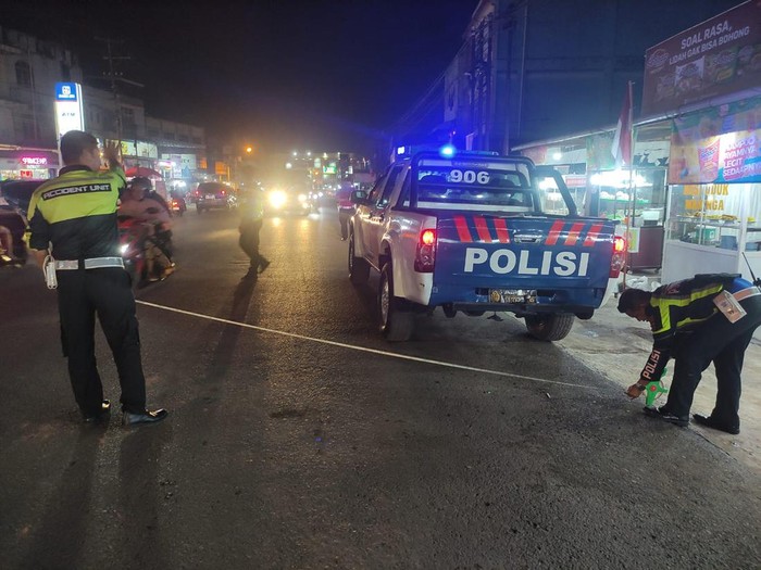 Polisi melakukan olah TKP kecelakaan antara truk dan pemotor di Jambi.