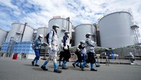 Para jurnalis dipandu di dekat tangki berisi air limbah radioaktif yang telah diolah di pembangkit listrik tenaga nuklir Fukushima Daiichi, Okuma, Jepang, Minggu (27/8/2023).  