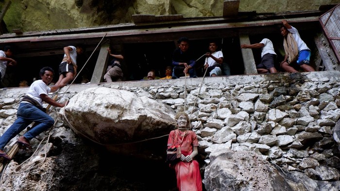 Sejumlah kerabat membersihkan dan mengganti pakaian patung atau tau-tau saat ritual manene tau-tau di Londa, Toraja Utara, Sulawesi Selatan, Selasa (29/8/2023). Ritual adat masyarakat Toraja yang diadakan setiap lima tahun tersebut merupakan bentuk penghormatan kepada leluhur mereka yang telah meninggal dan saat ini menjadi daya tarik wisatawan untuk berkunjung ke Toraja. ANTARA FOTO/Sakti Karuru/rwa.