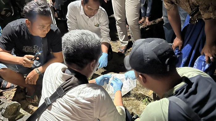 Petugas kepolisian, TNI, dan tim medis saat memeriksa mayat bayi yang ditemukan terkubur di Desa Larangan Perreng, Kecamatan Pragaan, Sumenep.
