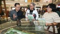 Chief Marketing Officer Kota Podomoro Tenjo Zaldy Wihardja (kiri) menyerahkan sertifikat penandatanganan AJB, piagam apresiasi AJB, dan pemberian souvenir spesial kepada konsumen di Main Atrium Senayan City Mall, Jakarta.  