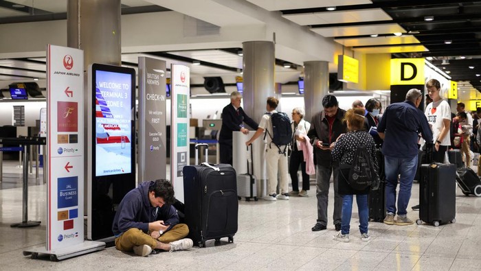 Potret Penumpang Terlantar di Bandara Inggris Akibat Gangguan Teknis A British Airways staff member speaks to passengers at Heathrow Airport, as Britain's National Air Traffic Service (NATS) restricts UK air traffic due to a technical issue causing delays, in London, Britain, August 28, 2023. REUTERS/Hollie Adams